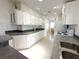 Well-lit kitchen features white cabinets and appliances, and neutral countertops with an eat-in space in the background at 217 Blackburn Blvd, North Port, FL 34287