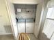 The laundry closet has a full-size washer and dryer, plus additional storage shelves for laundry and cleaning supplies at 217 Blackburn Blvd, North Port, FL 34287