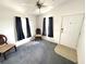 Living room featuring chairs, windows with curtains, a ceiling fan, and a door at 217 Blackburn Blvd, North Port, FL 34287