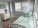 Well-lit bedroom featuring a twin bed, a white dresser, and plantation shutters at 232 Fiesole St, Venice, FL 34285