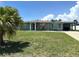 Charming single-story home featuring a well-maintained lawn, carport and mature palm trees at 232 Fiesole St, Venice, FL 34285