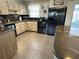 Bright kitchen featuring a black refrigerator and range, plus wood cabinets and tile flooring at 232 Fiesole St, Venice, FL 34285