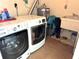 Functional laundry room featuring modern washer and dryer units and a utility sink at 232 Fiesole St, Venice, FL 34285