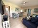 Bright living room with light wood floors, comfortable seating, and a modern entertainment center at 232 Fiesole St, Venice, FL 34285
