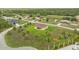 An overhead view of a lovely yellow home set on a sprawling green lawn with mature landscaping in a peaceful community at 2479 Grandview Dr, North Port, FL 34288