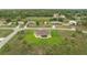 A serene aerial view of a yellow single-story home amid lush greenery and scattered palm trees in a tranquil neighborhood at 2479 Grandview Dr, North Port, FL 34288