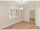 Bright dining room featuring wood-look floors, a modern chandelier, and large window with plantation shutters at 2479 Grandview Dr, North Port, FL 34288