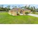 Charming one-story yellow home boasts lush green lawn, arched entryway, and a welcoming two-car garage at 2479 Grandview Dr, North Port, FL 34288