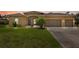 Inviting front exterior featuring a well-maintained lawn and a charming two-car garage, combining curb appeal and functionality at 2479 Grandview Dr, North Port, FL 34288