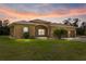 Charming single-story home boasting a well-manicured lawn and inviting curb appeal at sunset at 2479 Grandview Dr, North Port, FL 34288