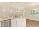 Spacious kitchen featuring stainless dishwasher and granite breakfast bar with pendant lighting at 2479 Grandview Dr, North Port, FL 34288