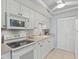 Bright kitchen featuring white cabinetry, modern appliances, and tile flooring at 255 The Esplanade N # 106, Venice, FL 34285