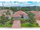 Aerial view of a well-maintained home with a red tile roof, brick driveway, and mature landscaping at 2944 Oriole Dr, Sarasota, FL 34243