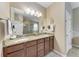 Bathroom with granite countertop, double sinks, wood cabinets, and tile flooring at 2944 Oriole Dr, Sarasota, FL 34243