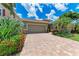 Home featuring a paver driveway leading to a two-car garage, complemented by vibrant landscaping at 2944 Oriole Dr, Sarasota, FL 34243