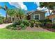 Charming home featuring lush landscaping, including palm trees, colorful flowers, and manicured shrubs at 2944 Oriole Dr, Sarasota, FL 34243