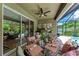 Beautiful covered patio with an outdoor dining table, ceiling fans, and a view of the pool, perfect for entertaining at 2944 Oriole Dr, Sarasota, FL 34243