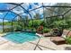 The inviting screened-in pool area offers a sparkling pool, comfortable lounge chairs, and lush landscaped surroundings at 2944 Oriole Dr, Sarasota, FL 34243