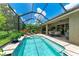 Inviting screened-in pool area showcases a sparkling pool, a cozy dining area, and meticulously landscaped surroundings at 2944 Oriole Dr, Sarasota, FL 34243