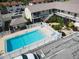 An aerial shot of the community pool area surrounded by condos, landscaping and parking at 320 Base E Ave # 215, Venice, FL 34285