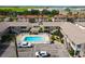 An elevated view showcasing the community pool, complex buildings, mature trees, and ample parking at 320 Base E Ave # 215, Venice, FL 34285