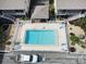 Aerial view of a sparkling community pool, surrounding landscaping, and nearby parking at 320 Base E Ave # 215, Venice, FL 34285