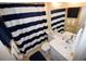 Well-lit bathroom with a white sink, blue and white shower curtain at 320 Base E Ave # 215, Venice, FL 34285