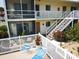 Inviting condo exterior featuring a cozy patio with lounge chairs and well-maintained landscaping at 320 Base E Ave # 215, Venice, FL 34285