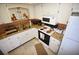 Bright kitchen featuring white cabinets, granite countertops, and copper backsplash at 320 Base E Ave # 215, Venice, FL 34285