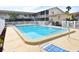 Bright community pool area with lounge chairs surrounded by a white picket fence at 320 Base E Ave # 215, Venice, FL 34285
