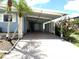 Spacious carport area offering covered parking and protection from the elements, with lush landscaping at 344 Mariner Dr, North Port, FL 34287