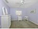 Cozy bedroom with a ceiling fan, lilac walls, and white wicker furniture at 346 Roseling Cir, Venice, FL 34293