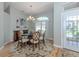 Bright dining room with wood flooring, decorative rug, chandelier, and large windows at 346 Roseling Cir, Venice, FL 34293