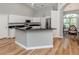 Bright kitchen with stainless steel appliances, granite countertops, an island, and ample cabinet space at 346 Roseling Cir, Venice, FL 34293
