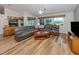 Comfortable living room featuring wood floors, a ceiling fan, and plenty of natural light from large windows at 346 Roseling Cir, Venice, FL 34293
