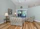 Cozy living room with hardwood floors, a ceiling fan, and a sliding door overlooking the pool at 346 Roseling Cir, Venice, FL 34293