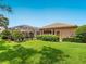 Well-maintained backyard featuring a screened lanai, lush landscaping, and a grassy lawn at 355 Swallow Cir, Venice, FL 34285
