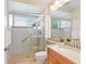 Updated bathroom with a glass-enclosed shower, tile surround, and wood vanity at 355 Swallow Cir, Venice, FL 34285