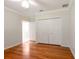 Bedroom with hardwood floors, white trim and doors, and a view into the ensuite bath at 355 Swallow Cir, Venice, FL 34285