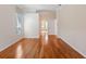 Inviting bedroom with hardwood flooring, window with blinds, and a hallway to the bathroom at 355 Swallow Cir, Venice, FL 34285