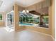 Bright dining area with travertine flooring, chandelier, and backyard view from large windows and sliding glass doors at 355 Swallow Cir, Venice, FL 34285