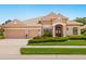 Charming single-story home with a tile roof, three-car garage, and beautifully landscaped front yard with flowers at 355 Swallow Cir, Venice, FL 34285