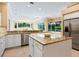 Bright kitchen with granite countertops, stainless steel appliances, and views of the living area at 355 Swallow Cir, Venice, FL 34285