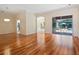 Open living room with hardwood floors, neutral walls, arched doorways and a view of the screened-in pool area at 355 Swallow Cir, Venice, FL 34285