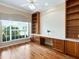 Bright office featuring a built-in desk and shelving, a large window, hardwood floors, and a ceiling fan at 355 Swallow Cir, Venice, FL 34285