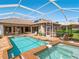 Inviting screened-in pool and spa area with chairs, and tile patio perfect for outdoor living at 355 Swallow Cir, Venice, FL 34285