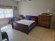 Bedroom with tiled floors, warm toned furniture, and a bright sunny window at 3730 Cadbury Cir # 703, Venice, FL 34293
