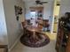 Charming dining area featuring a round wooden table, china cabinet, and a decorative rug at 3730 Cadbury Cir # 703, Venice, FL 34293