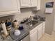 Clean kitchen featuring granite countertops, white cabinets, and stainless steel sink at 3730 Cadbury Cir # 703, Venice, FL 34293