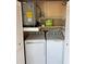 Enclosed laundry closet with a washer, dryer, water heater, and storage shelves at 3862 59Th W Ave # 4180, Bradenton, FL 34210